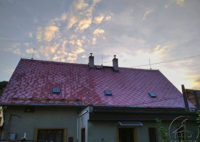 Částečně vyčištěná eternitová střecha domu u Sázavy silně porostlá mechem