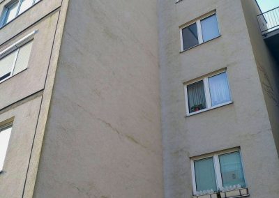 Znečištěná fasáda panelového domu v Praze 10