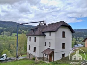 čištění střechy vysokého domu za pomoci plošiny