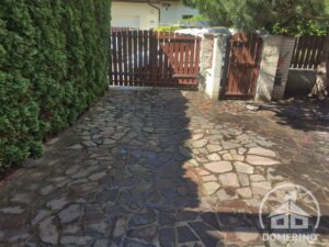 Znečištěná zámková dlažba u rodinného domu před čištěním