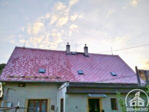 Částečně vyčištěná eternitová střecha silně porostlé mechem
